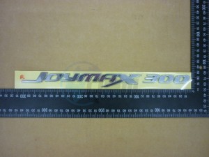 Product image: Sym - 87126-L3C-000 - R. BODY COVER EMBLEM 'JOYMAX 300' 